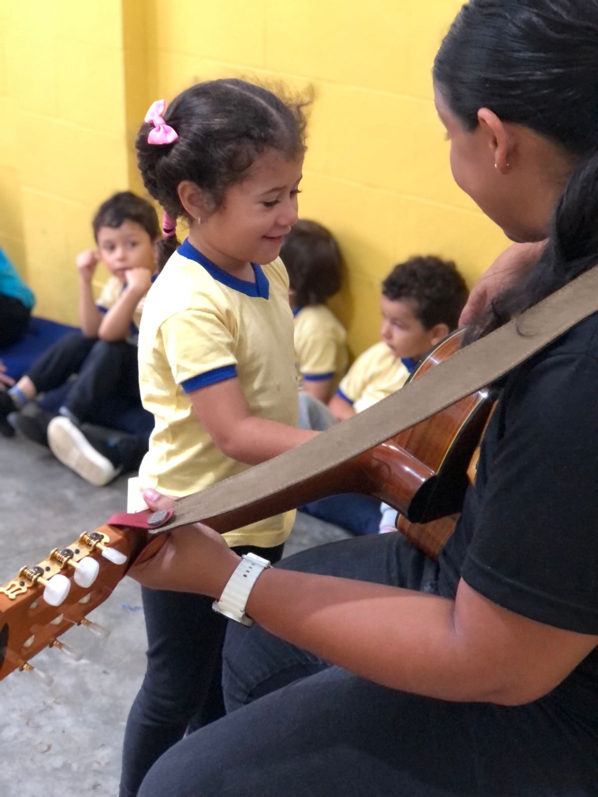Professora tocando violão para aluna